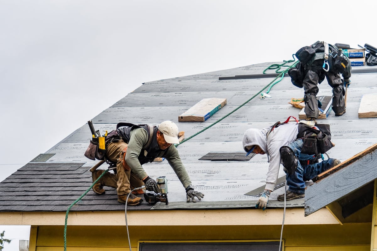 Crew installing new roof shingles