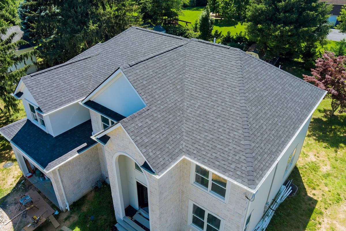 Worker installing new shingles during a roof replacement