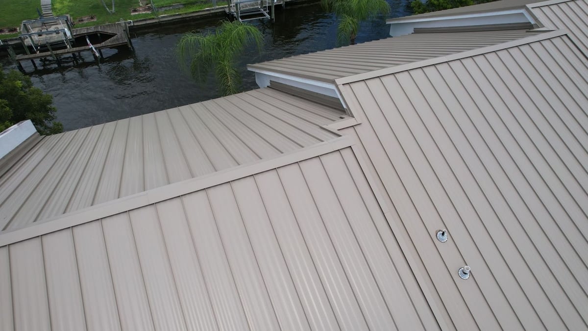 Tan standing seam metal roof hips and valleys on a commercial building near a canal in Cape Coral, FL