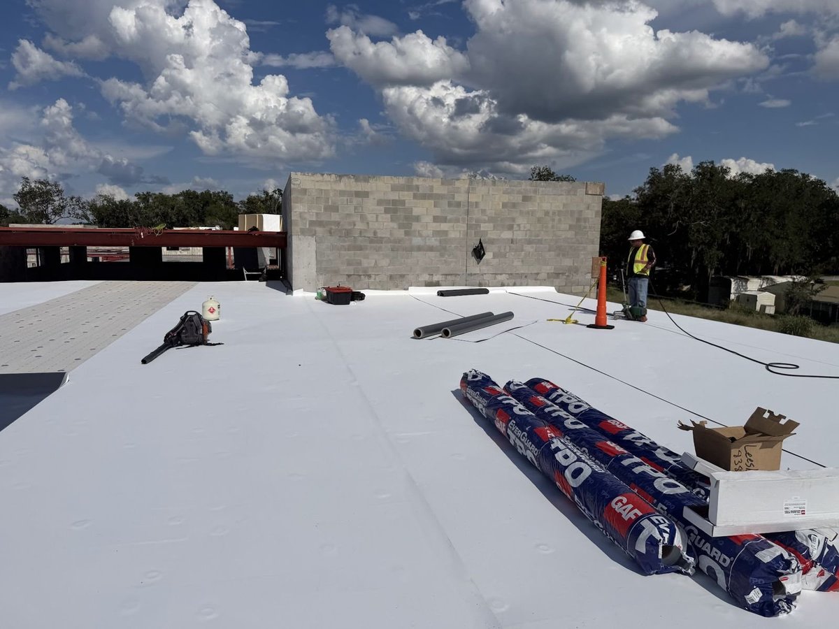Newly installed white TPO single-ply membrane on a commercial flat roof in Leesburg, FL, with GAF EverGuard TPO rolls