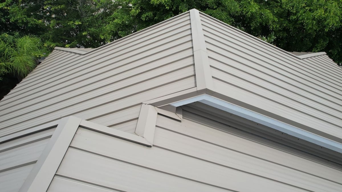 Close view of standing seam metal hip and ridge trim after a tile-to-metal roof conversion in Cape Coral, FL